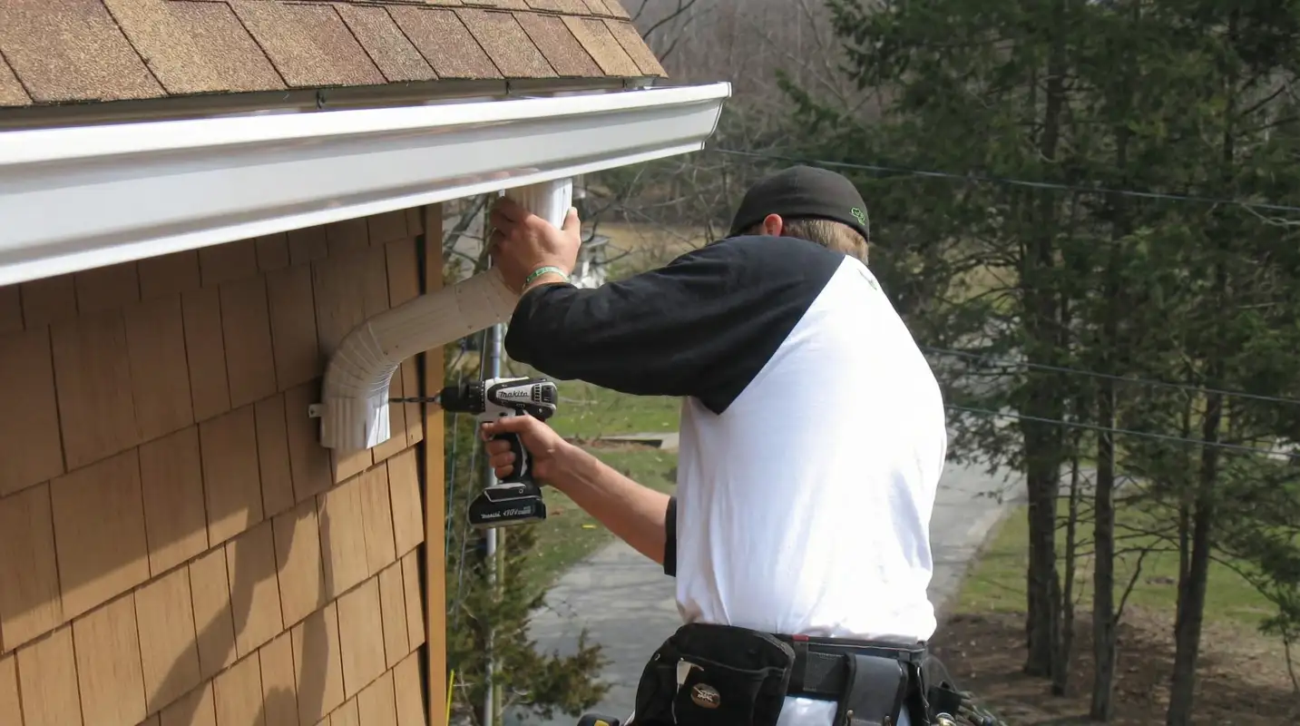 Professional contractor installing tan vinyl siding panels on a residential home exterior in Pasadena, CA